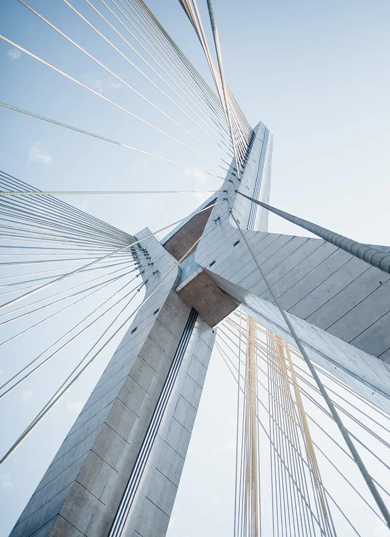 Looking up at a concrete pylon of a bridge, representing infrastructure